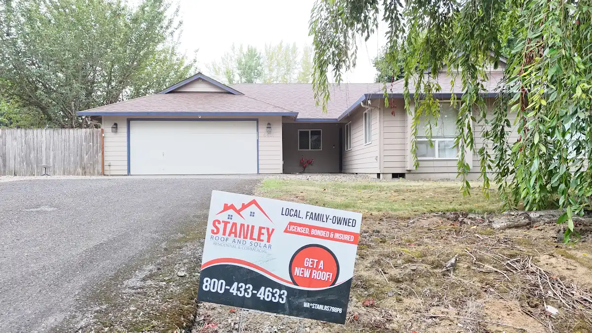Completed roof replacement with a Stanley Roof and Solar yard sign in Green Arbor Village, La Center, WA