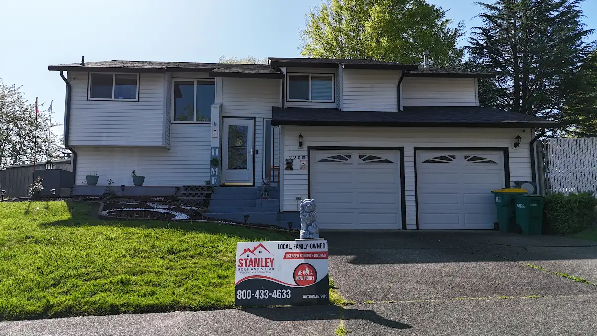Front of a split-level home in Troutdale, OR with a Stanley Roof and Solar sign before the roof replacement